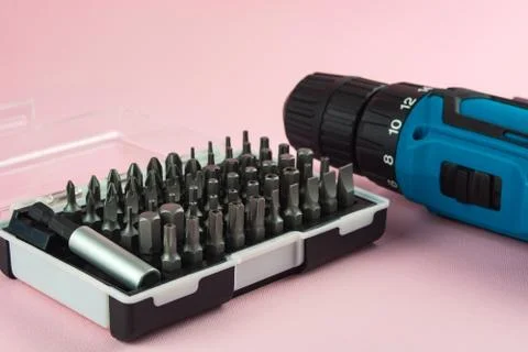 A screwdriver with a battery and a set of bits for it Stock Photos