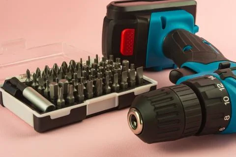 A screwdriver with a battery and a set of bits for it Stock Photos