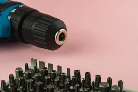 A screwdriver with a battery and a set of bits for it Stock Photos