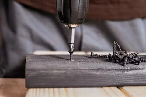 Screwdriver Bit Inserting Fastener Into Wood Plank Stock Photos