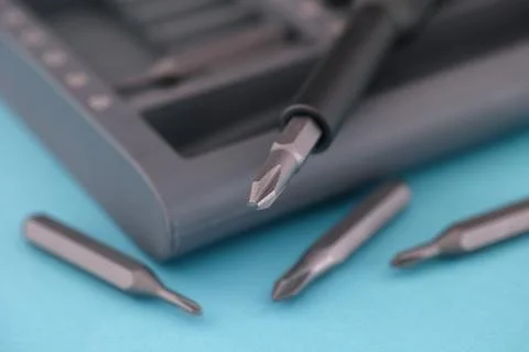 A screwdriver bit set lying on a blue surface Stock Photos