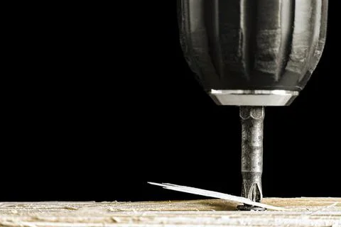 Screwdriver bit twists self-tapping screw into Stock Photos