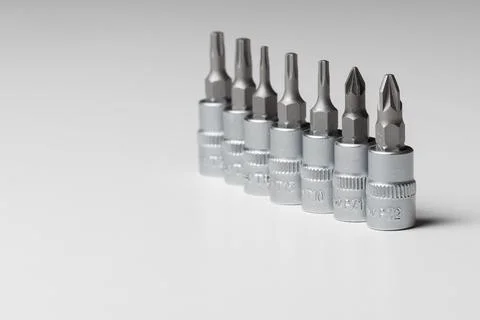 Screwdriver bits, different designs on grey background. Copy space. Close up Stock Photos