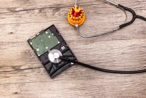 Screwdriver cures a hard disk with stethoscope. Stock Photos