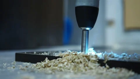 With a screwdriver with a drill, we drill holes for the furniture loop. making a Stock Footage 154954801