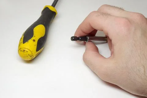 Screwdriver extension bar in mans hand, showing hex shank side. plastic yel.. Stock Photos