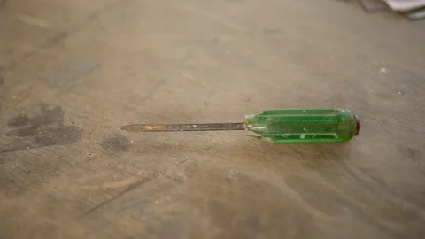 Screwdriver flat mouth with green plastic handle on table. Stock Footage 123887939