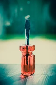 Screwdriver - flat red screwdriver isolated on vintage wooden background. Eng Foto stock