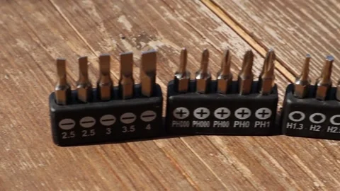 The screwdriver head kits stand in a row on the brown wooden floor. Close-up Vídeos de archivo 144800037