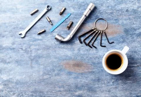 Screwdriver, hex keys, socket wrench, bits for a screwdriver and a cup of coffee Stock Photos