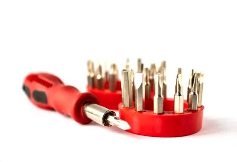Screwdriver with a red handle and a set of bits on a white background. Stock Photos