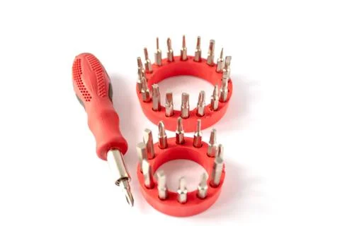 Screwdriver with a red handle and a set of bits on a white background. Stock Photos