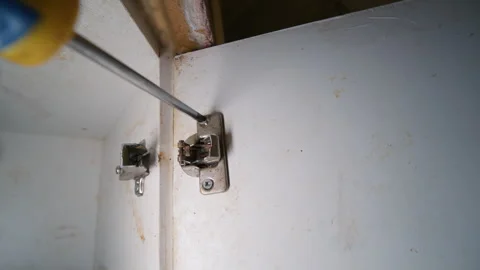 Screwdriver Removing Screw from Broken Cabinet Door Hinge | Damaged Silumin Stock Footage 332315750