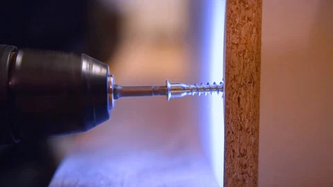 Screwdriver screw a screw into a wooden material Stock Footage 122004751