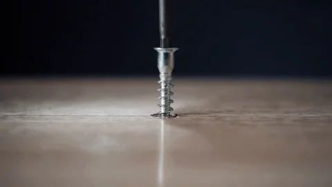Screwdriver spins a screw into a wooden board Stock Footage 117115341