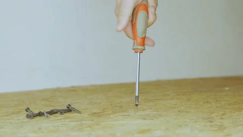 Screwdriver unscrew the self-tapping screw from a oriented strand board. Close Stock Footage 201256176
