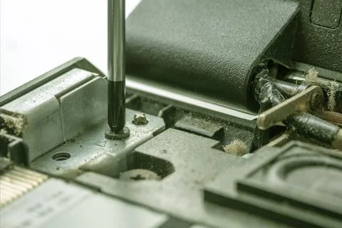 The screwdriver unscrews the fastening bolt of the processor computer board. Foto stock