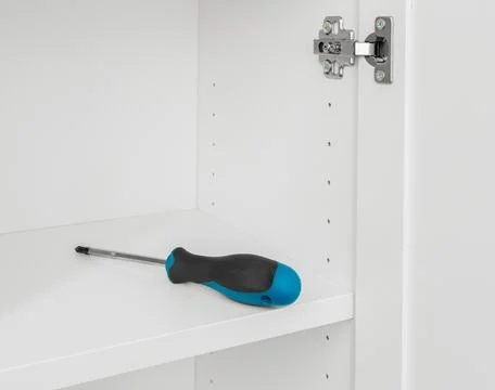 The screwdriver is on the white shelf. Stock Photos