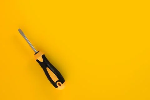 Screwdriver on a yellow background with copy space Stock Illustration