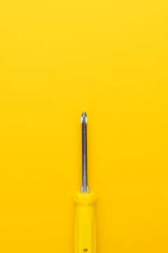 Screwdriver on yellow background Stock Photos