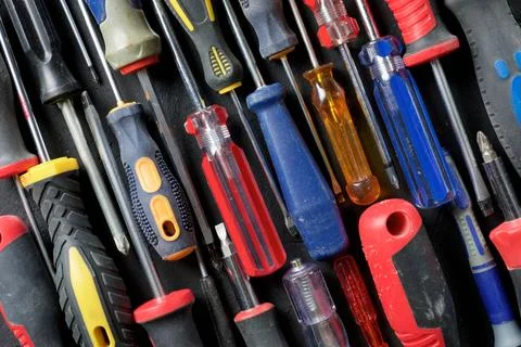 Screwdrivers of different sizes on a black table Fotos de archivo