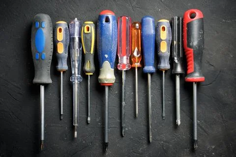 Screwdrivers of different sizes on a black table Stock Photos