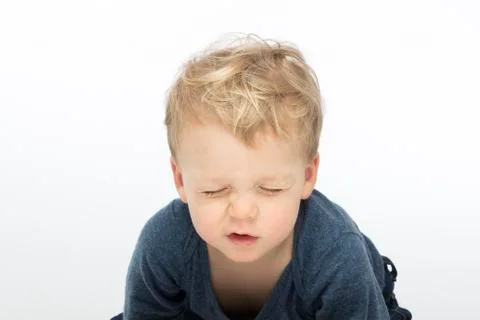 Screwed-up toddler on white background. Studio shot Foto stock