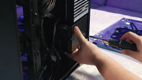 Screwing the drive cage with hard drive and SSD to the computer case Stock Footage 328987345