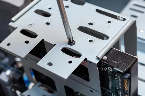 Screwing installing upgrading hdd drive disk on a place in the service Stock Photos