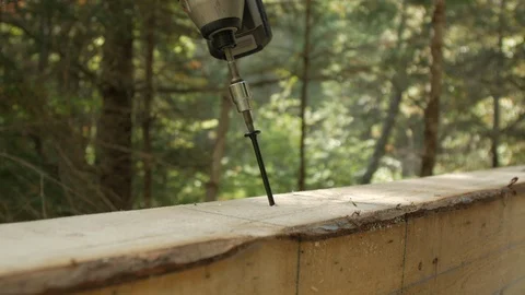 Screwing in log cabin, forest in background with natural lighting, closeup 4k Stock Footage 120314471