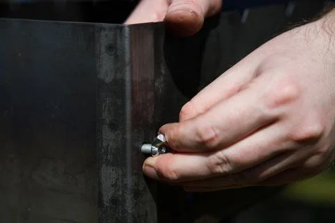 Screwing up a nut by hand. Close up. Stock Photos