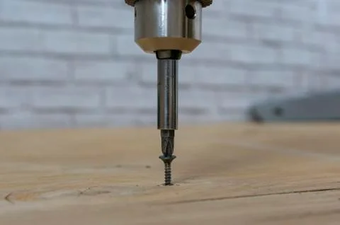 Screwing the screw into the board Foto stock
