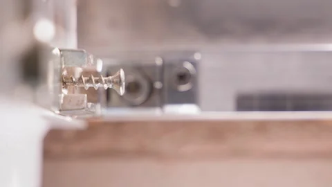 Screwing a screw with a screwdriver close-up on a blurred background Stock Footage 242387637