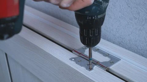 Screwing the self-tapping screw into the door frame structure Stock Photos