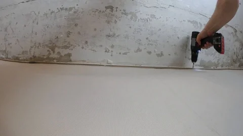 Screwing to the wall under the stretched ceiling Stock Footage 88485285