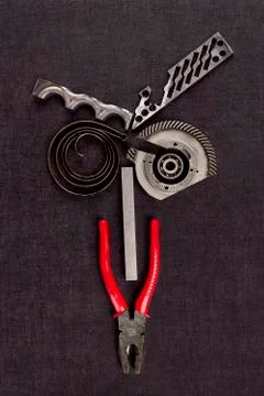 Screws, cogwheels and mechanical components on concrete. Stock Photos