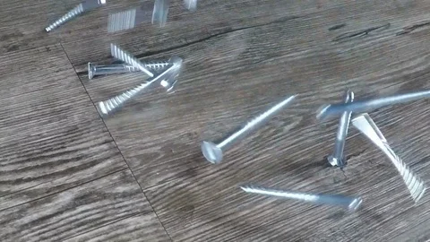 Screws falling onti a wooden table Stock Footage 122836688