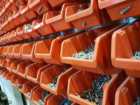 Screws in orange storage boxes in a workshop Stock Photos