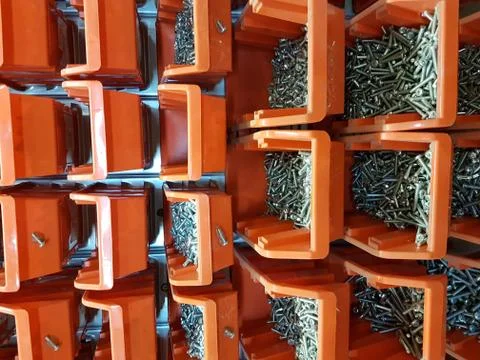 Screws in orange storage boxes in a workshop Stock Photos