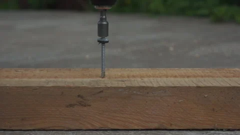 Screws a self-tapping screw with a screwdriver into a board in the fresh air Video stock 131258833
