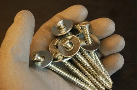 Screws with a stell washers in the hand of the assembler Stock Photos