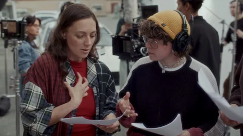 Script Supervisor and Actors Rehearsing Dialogue Scene on Location 库存影片 336699716