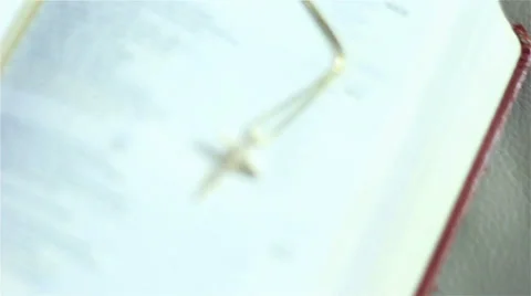 Scroll past open Bible with gold cross necklace on it 스톡 동영상 39076124