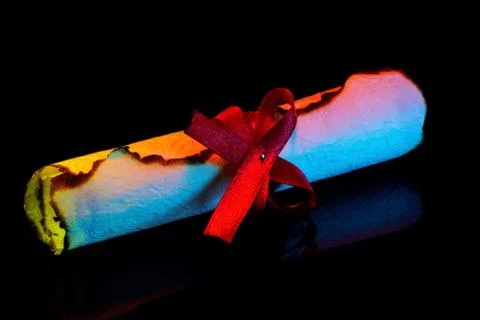 Scroll with a red bow-the texture of old paper for the creativity of writing. Stock Photos