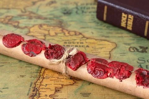 Scroll with seven seals on ancient world map with closed holy bible book Stockfoto's