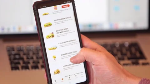 Scrolling and typing on 'Burger King' Fast food app on Android mobile phone Stock Footage 146910357