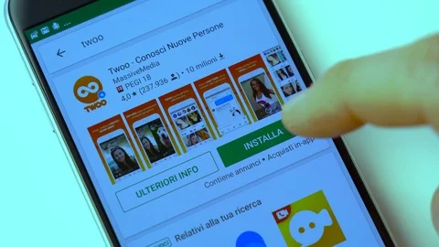 Scrolling apps in the Play Store and installing Twoo on your smartphone Stock Footage 106930729