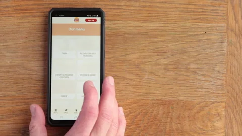 Scrolling 'Burger King' menu on android phone in the time of Covid in the UKK Stock Footage 147265271