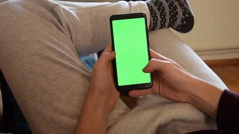 Scrolling on the green screen on couch Stock Footage 129767971