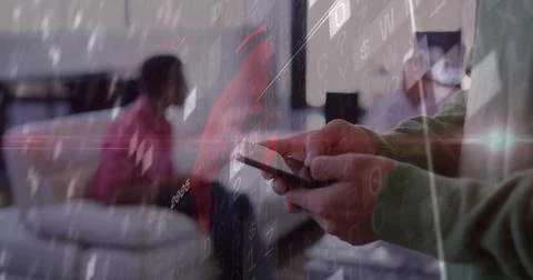Scrolling male office worker using smartphone in office lounge, with monitors, 库存照片